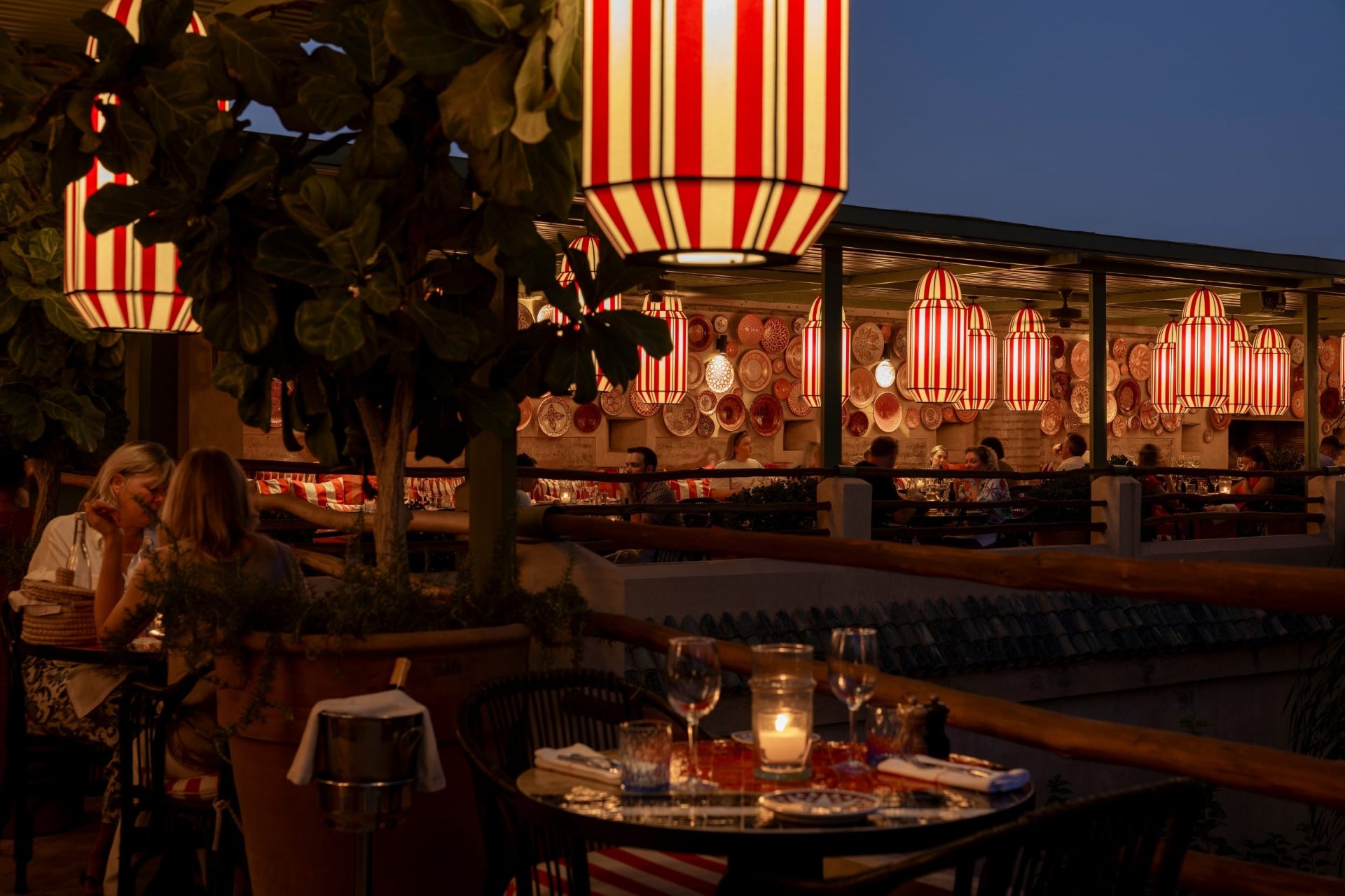 El Fenn de nuit, lanternes rayées rouge et blanc et tables dressées sur la terrasse